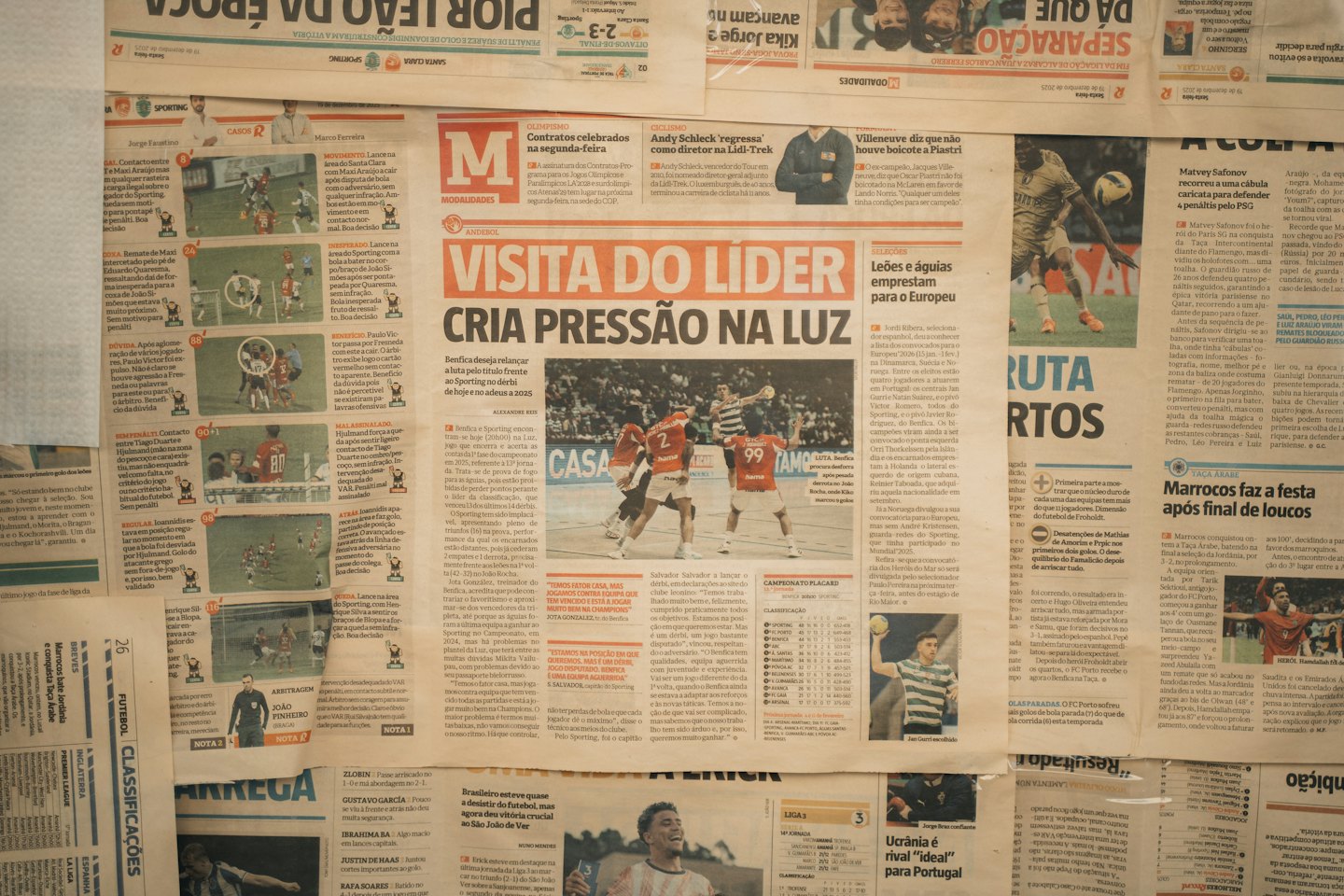 Overlapping newspaper pages with various sports articles and headlines.